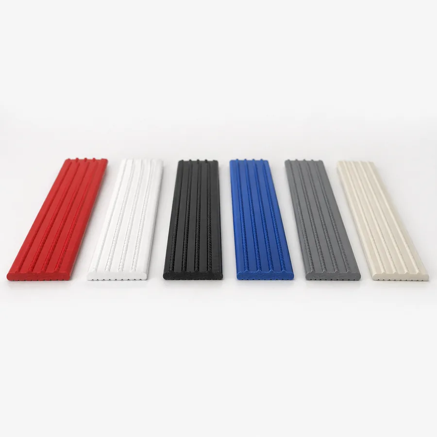 Sechs gleiche Kunststoffprofile in Rot, Weiß, Schwarz, Blau, Grau und Beige nebeneinander
