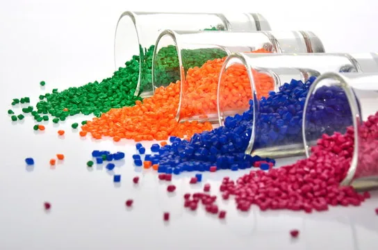Eingefärbtes Kunststoffgranulat in Grün, Orange, Blau und Pink als Ausgangsmaterial der Extrusion